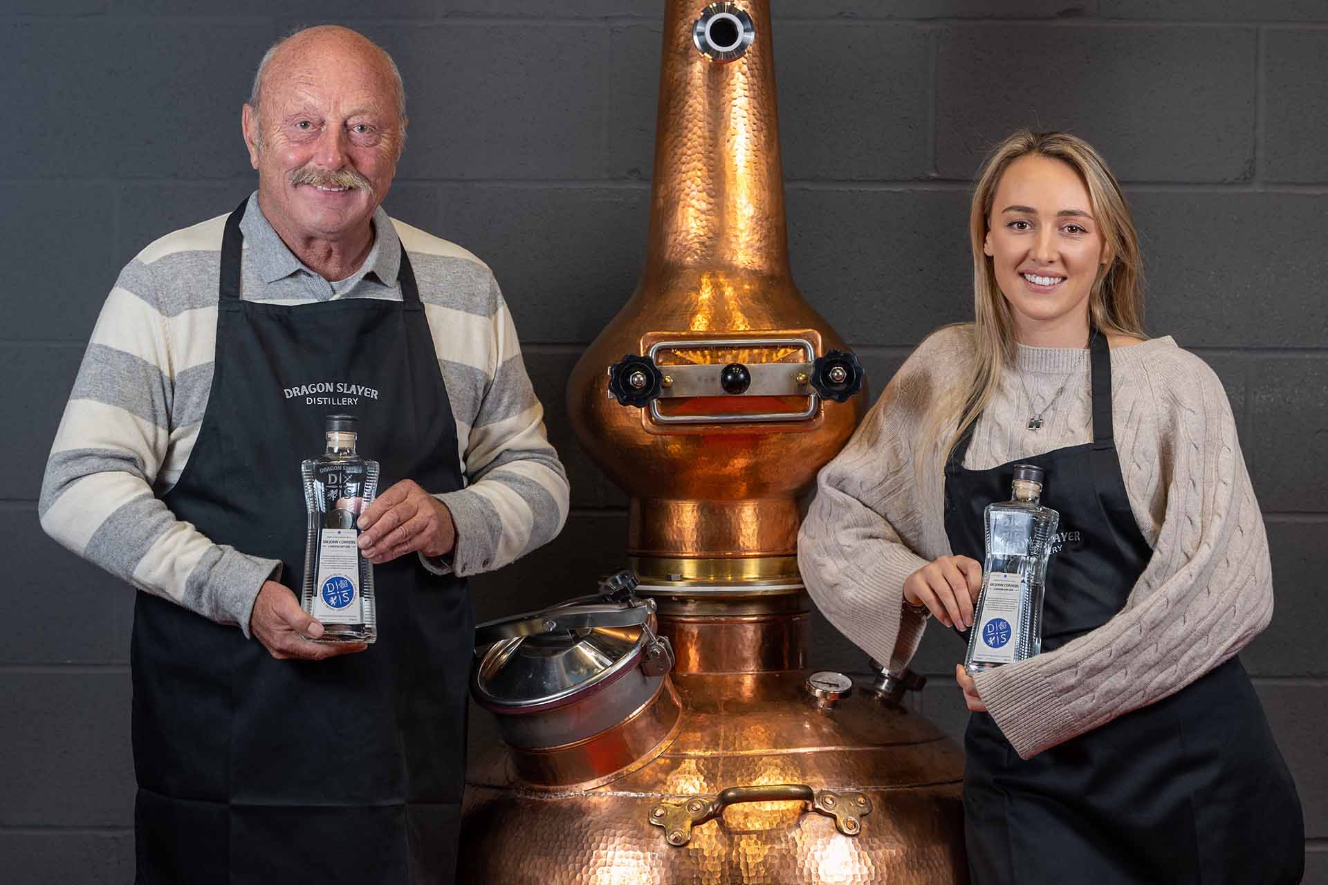 Dragon slayer Distillery founders standing next to gin still