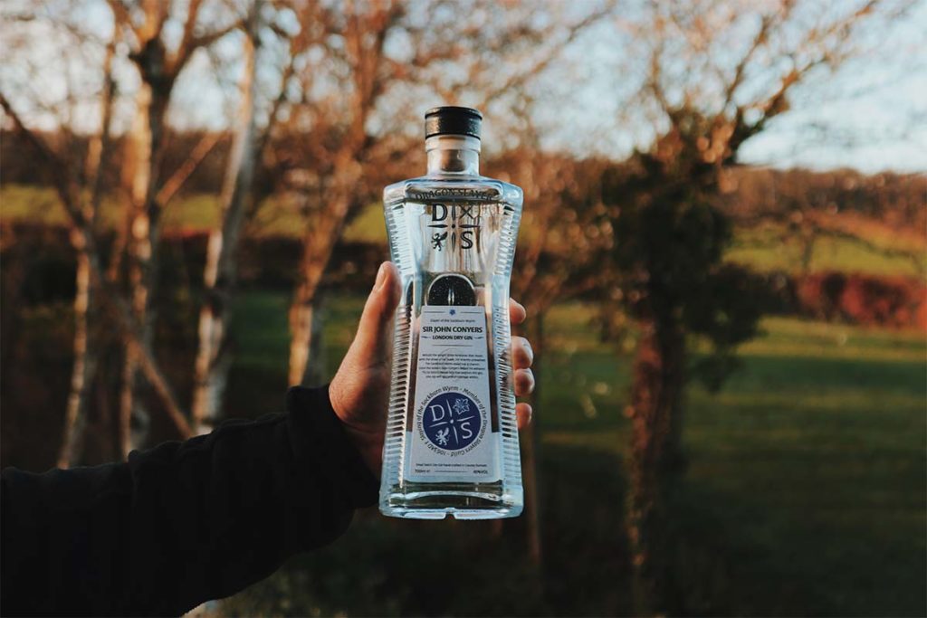 hand holding Dragon Slayer Gin bottle outside